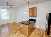 Thumbnail 1 of 21 - A kitchen with wooden floors and a black countertop.