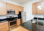 Thumbnail 3 of 21 - A kitchen with wooden cabinets and granite countertops.