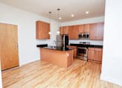 Thumbnail 6 of 21 - A kitchen with wooden floors and a black counter.
