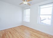 Thumbnail 12 of 21 - A room with wooden flooring and two windows.
