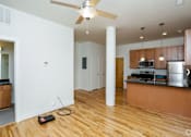Thumbnail 20 of 21 - A kitchen with wooden floors and a ceiling fan.
