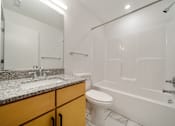 Thumbnail 7 of 9 - A white bathroom with a sink, toilet, and bathtub.