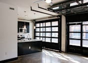 Thumbnail 8 of 8 - A kitchen with black cabinets and a large window.