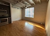Thumbnail 4 of 10 - A room with wooden floors and a window letting in sunlight.