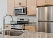 Thumbnail 4 of 9 - A kitchen with a stainless steel refrigerator, microwave, and oven.