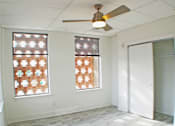 Thumbnail 4 of 5 - A room with a ceiling fan and two windows.