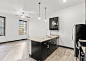Thumbnail 5 of 21 - A kitchen with black cabinets and a marble countertop.