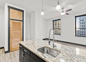 Thumbnail 6 of 21 - A kitchen with a granite countertop and a window overlooking a cityscape.