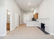 Thumbnail 4 of 9 - a white living room with a fireplace and a kitchen