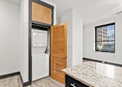 Thumbnail 10 of 21 - A kitchen with a white fridge and a wooden door.
