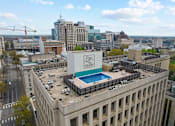 Thumbnail 1 of 21 - A large building with a swimming pool on the roof.