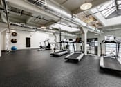 Thumbnail 4 of 17 - A gym with treadmills, exercise balls, and weights.
