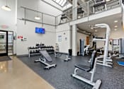 Thumbnail 5 of 17 - A gym with a variety of equipment including weights and a treadmill.