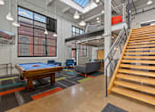 Thumbnail 2 of 17 - A room with a pool table and a staircase.