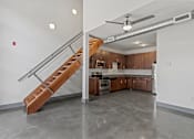 Thumbnail 11 of 17 - A modern kitchen with a staircase leading to the upper floor.