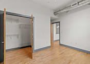 Thumbnail 17 of 17 - A room with a sliding door and a wooden floor.