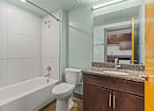 Thumbnail 13 of 17 - A white toilet sits next to a bathtub in a bathroom.