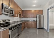 Thumbnail 10 of 17 - A kitchen with brown cabinets and stainless steel appliances.