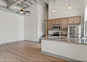 Thumbnail 3 of 20 - A kitchen with wooden cabinets and a granite countertop.