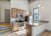 Thumbnail 2 of 20 - A kitchen with a granite countertop and stainless steel appliances.