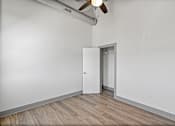 Thumbnail 8 of 20 - A room with a white door and a ceiling fan.