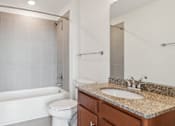 Thumbnail 8 of 10 - A white bathroom with a toilet, sink, and shower.