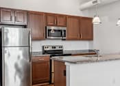 Thumbnail 4 of 10 - A kitchen with a stainless steel refrigerator, microwave, and oven.