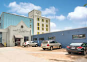 Thumbnail 1 of 10 - A car dealership with a sign that says "FIRST ON THE MARKET" on the side of the building.
