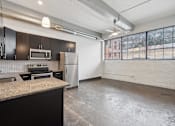 Thumbnail 5 of 13 - A kitchen with black cabinets and a granite countertop.