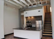 Thumbnail 2 of 5 - A kitchen with a stainless steel refrigerator and stove.