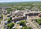 Thumbnail 1 of 22 - An aerial view of a town with a large building in the center.