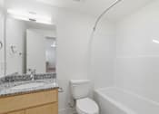 Thumbnail 21 of 22 - A white toilet sits next to a sink in a bathroom.