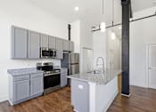 Thumbnail 16 of 22 - A modern kitchen with a granite countertop and stainless steel appliances.