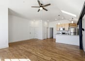 Thumbnail 10 of 22 - A room with a ceiling fan and wooden floors.
