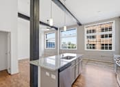 Thumbnail 8 of 22 - A kitchen with a large island and a view of the city.