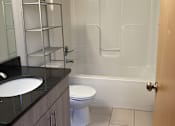 Thumbnail 7 of 7 - A white toilet sits in a bathroom next to a sink.