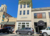 Thumbnail 1 of 7 - A building with a green awning and a sign that says "Wellness" is in the background.