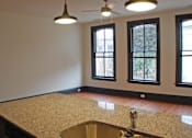 Thumbnail 6 of 7 - A kitchen with a granite countertop and a sink.