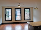 Thumbnail 3 of 7 - A room with a ceiling fan and three windows.