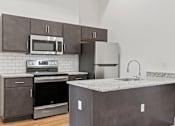 Thumbnail 3 of 9 - Kitchen space with stainless steel fridge, stove, microwave, dishwasher, and sink