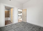 Thumbnail 8 of 24 - A room with a carpeted floor and two open doors.