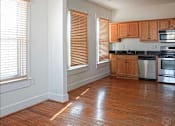 Thumbnail 4 of 8 - A kitchen with wooden floors and wooden cabinets.