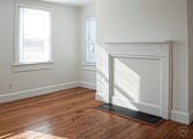 Thumbnail 6 of 8 - A room with a fireplace and a window.