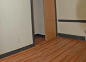 Thumbnail 3 of 6 - A room with a ceiling fan and a wooden floor.