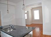 Thumbnail 22 of 22 - A kitchen with a black counter top and a sink.