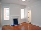 Thumbnail 20 of 22 - A room with a fireplace and a ceiling fan.