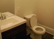 Thumbnail 15 of 22 - A white toilet sits next to a sink in a bathroom.