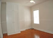 Thumbnail 11 of 22 - A room with a wooden floor and a window.