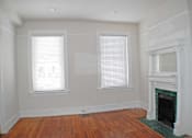 Thumbnail 7 of 22 - A room with a fireplace and two windows.
