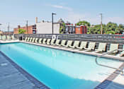 Thumbnail 12 of 13 - A large swimming pool with sun loungers on the side.
